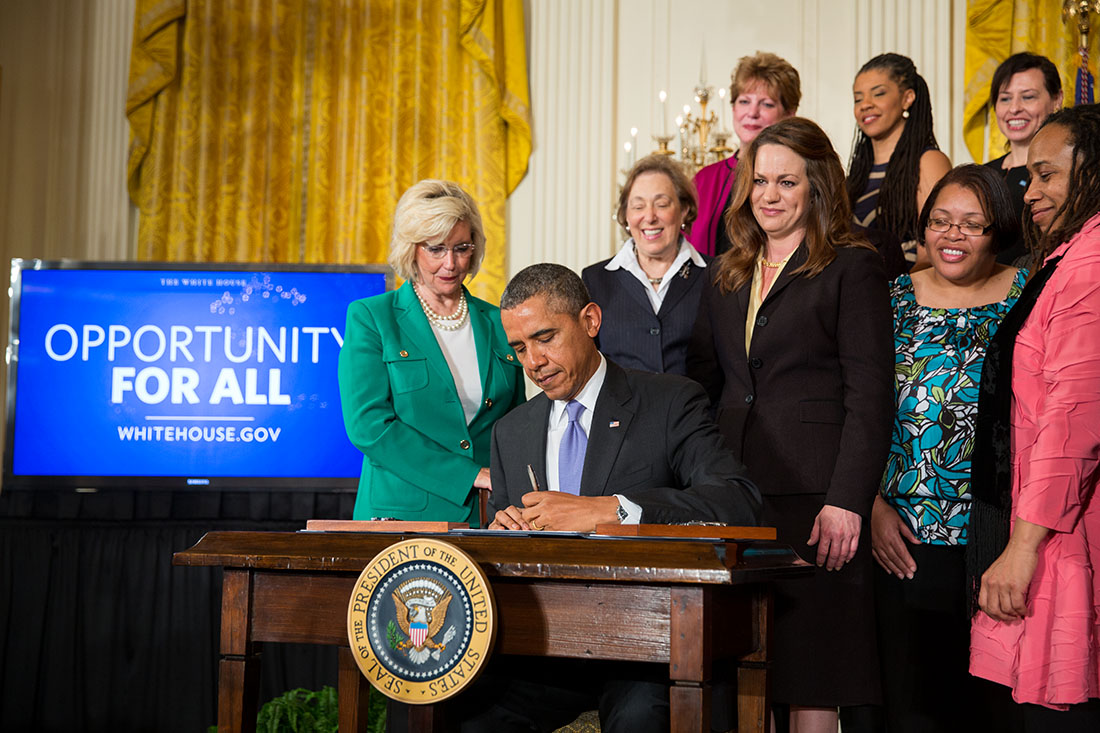 President Barack Obama signs executive actions to strengthen enforcement of equal pay laws for women, at an event marking Equal Pay Day, in the East Room of the White House, April 8, 2014.