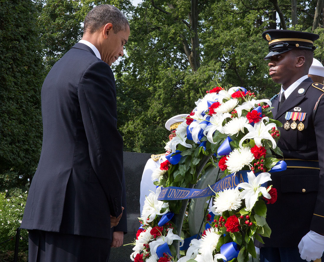 President Barack Obama bows his head during a  wreath laying ceremony to commemorate the 60th anniversary of the signing of the Armistice