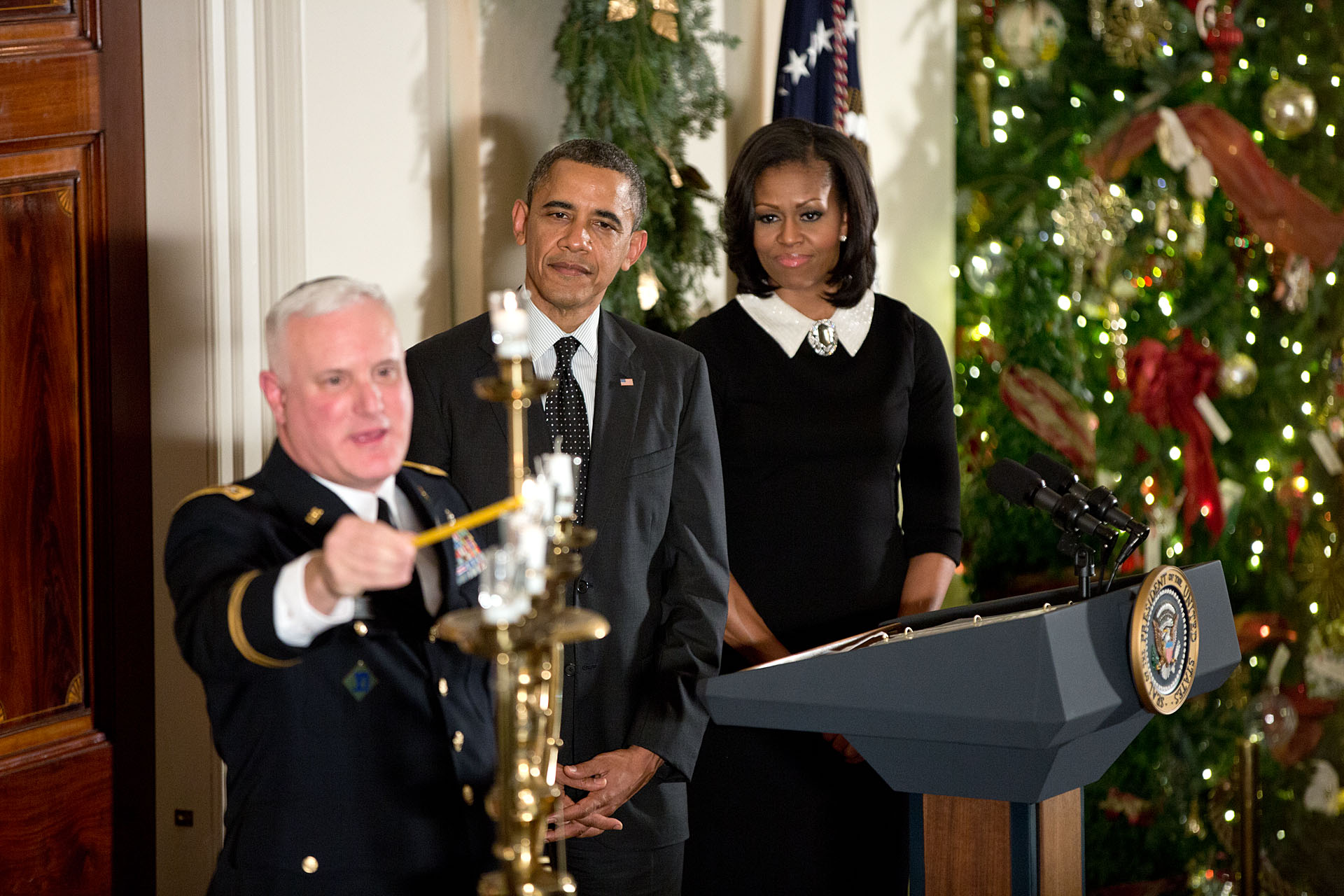 President Barack Obama, First Lady Michelle Obama, and Rabbi Larry Bazer participate in the Menorah lighting during the Hanukkah reception in the Grand Foyer of the White House, Dec. 13, 2012. (Official White House Photo by Pete Souza)