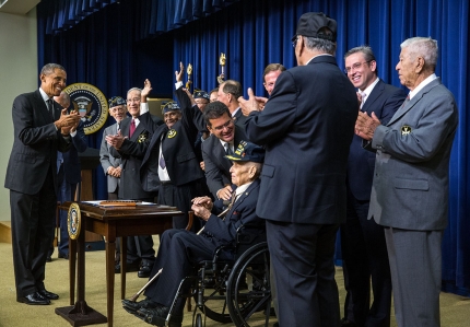 President Barack Obama leads an ovation for the Borinqueneers after he signed H.R. 1726