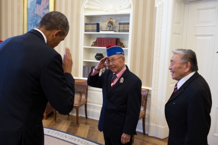President Barack Obama returns the salute from one of the members of the group of Japanese American WWII veterans during a meeting in the Oval Office 