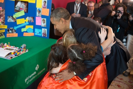President Obama hugs a group of young girl scouts who presented their project at the 2015 White House Science Fair 
