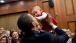 President Obama lifts up a baby during the U.S. Embassy greeting