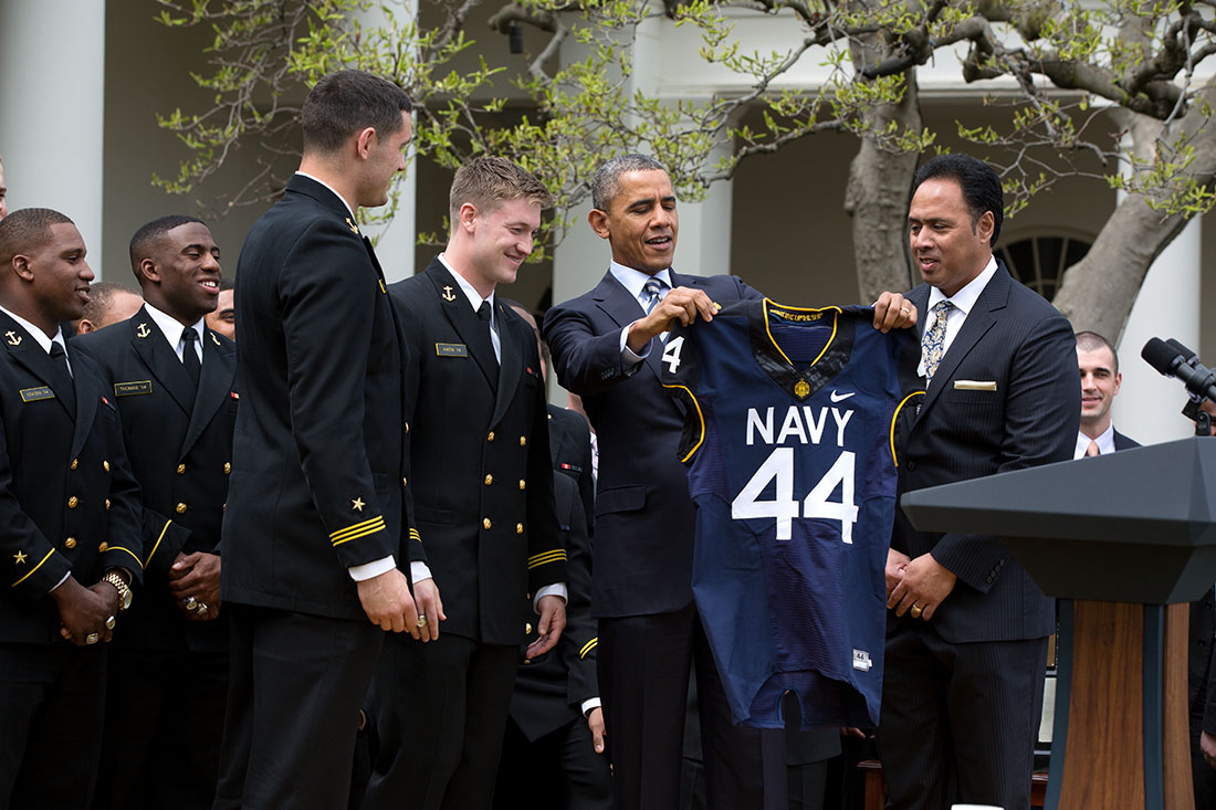 Midshipmen Matt Aiken and Cody Peterson present President Barack Obama with a Naval Academy football jersey during the Commander in Chief's Trophy presentation ceremony for the U.S. Naval Academy football team