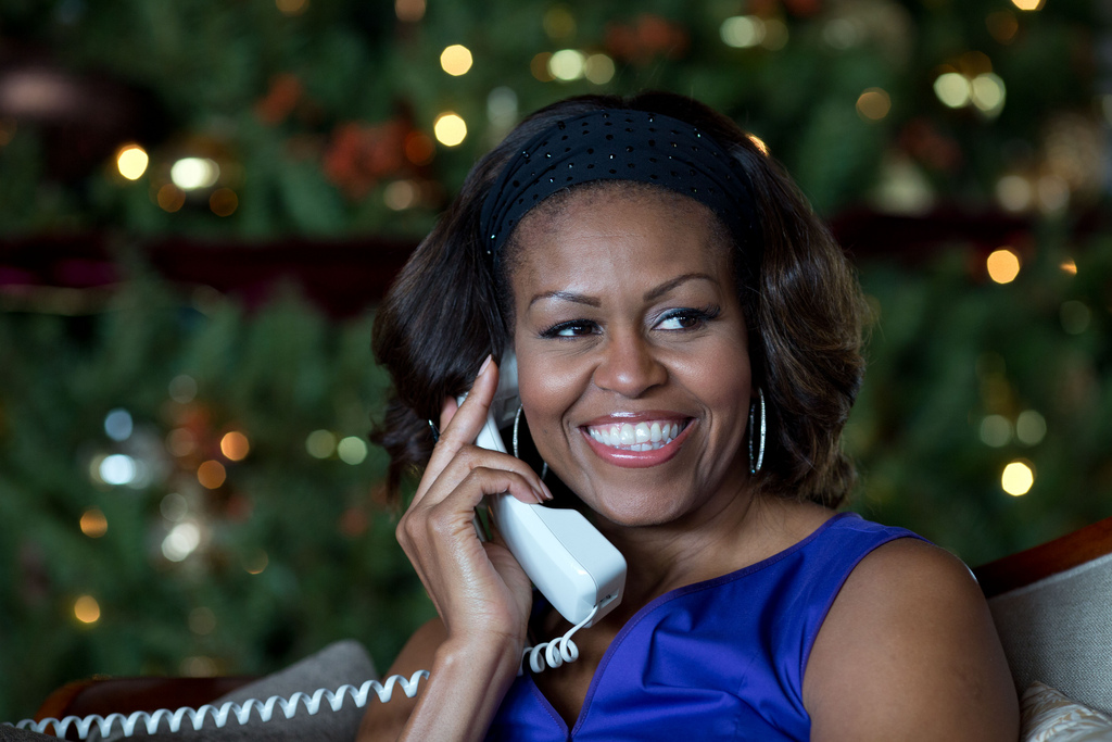 First Lady Michelle Obama reacts while talking on the phone to children across the country as part of the annual NORAD Tracks Santa program.