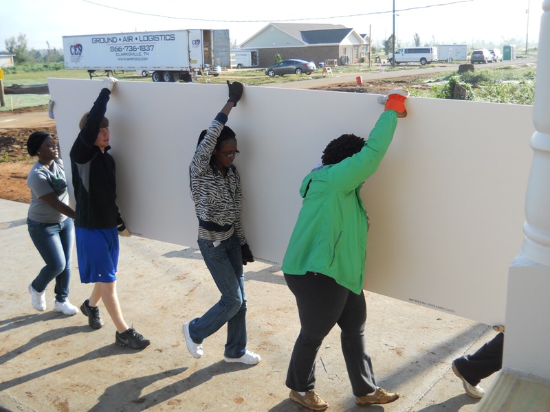 Students carrying sheetrock 
