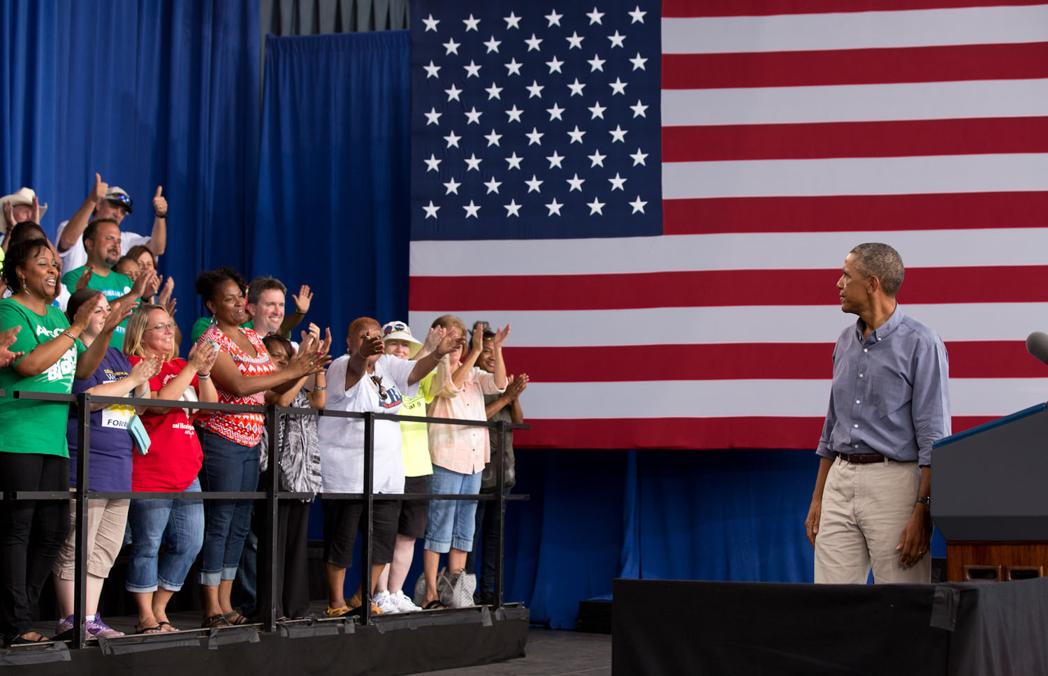 President Barack Obama looks back at the crowd behind him on the stage during remarks at the Milwaukee Laborfest