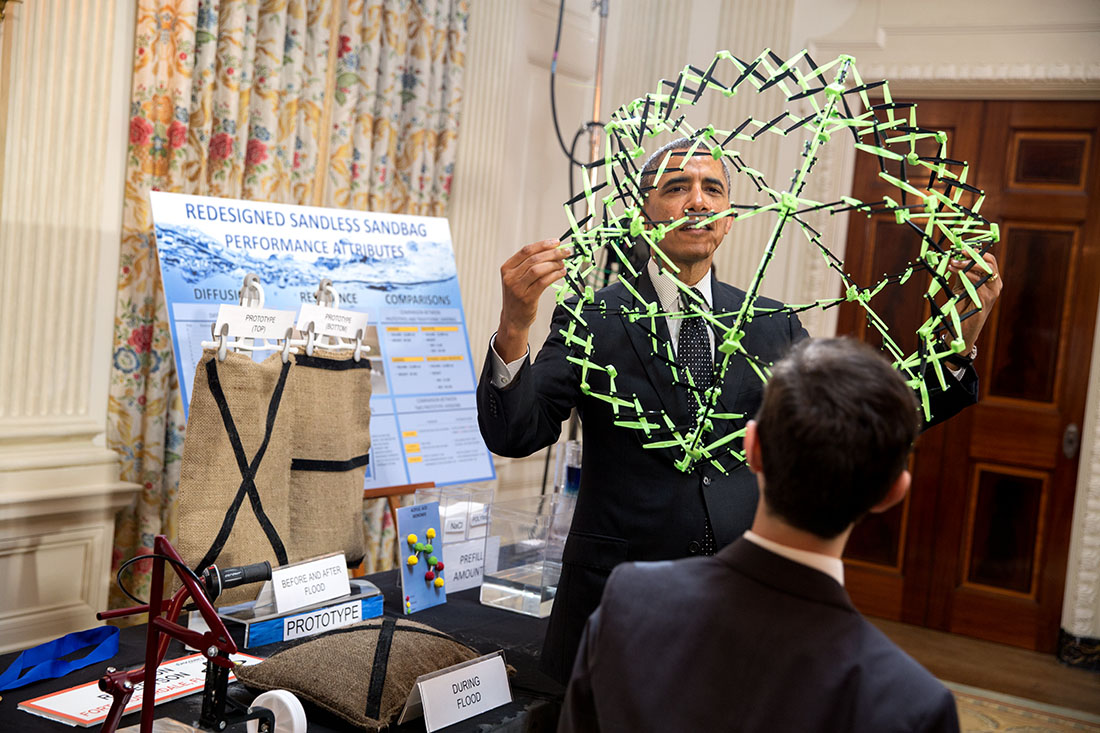 President Barack Obama holds a polymer while talking with Peyton Robertson, 12, about his projects during the 2014 White House Science Fair in the State Dining Room of the White House, May 27, 2014.