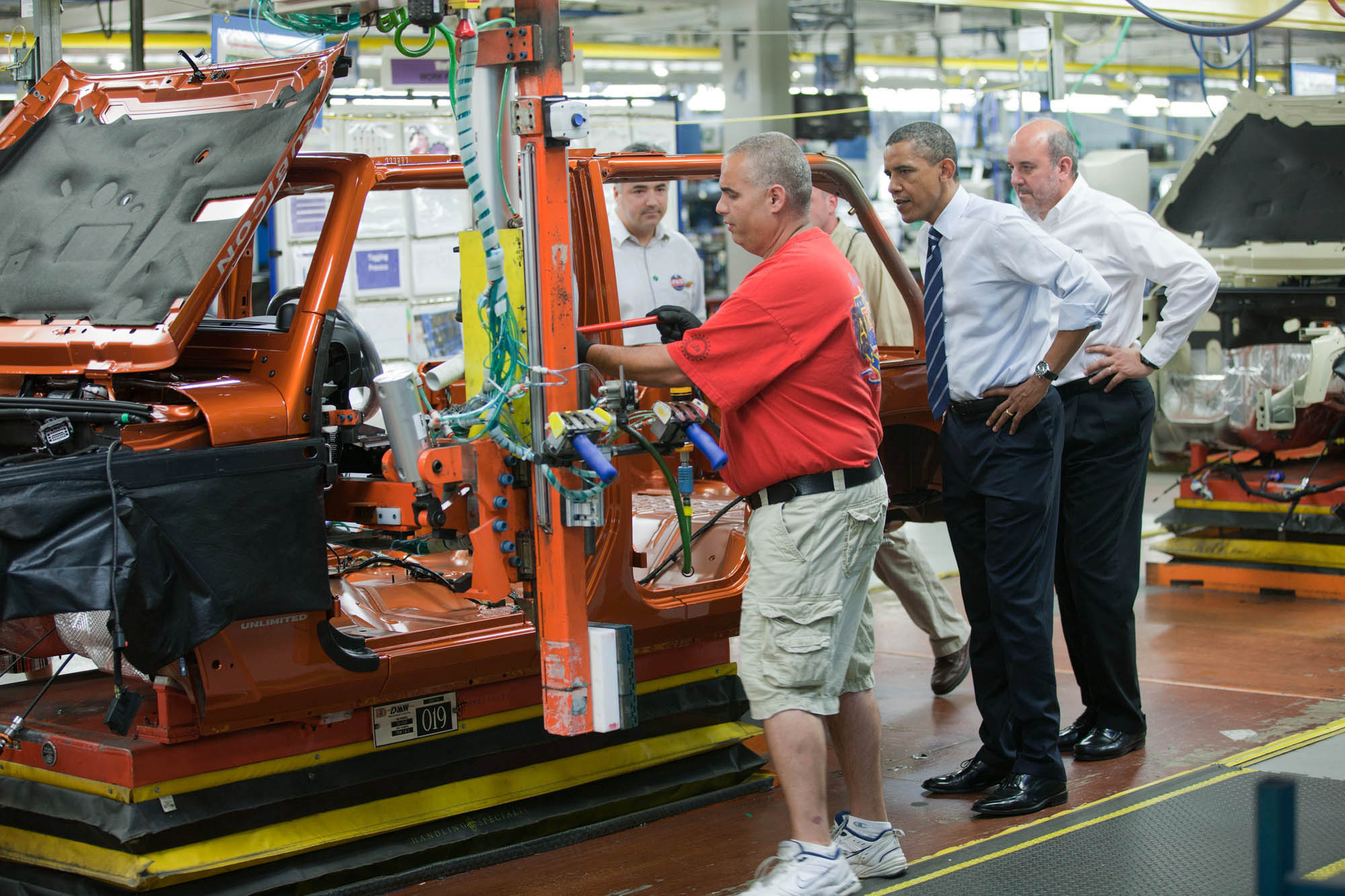 President Barack Obama watches as a center consul is installed in a 2011 Jeep Wrangler
