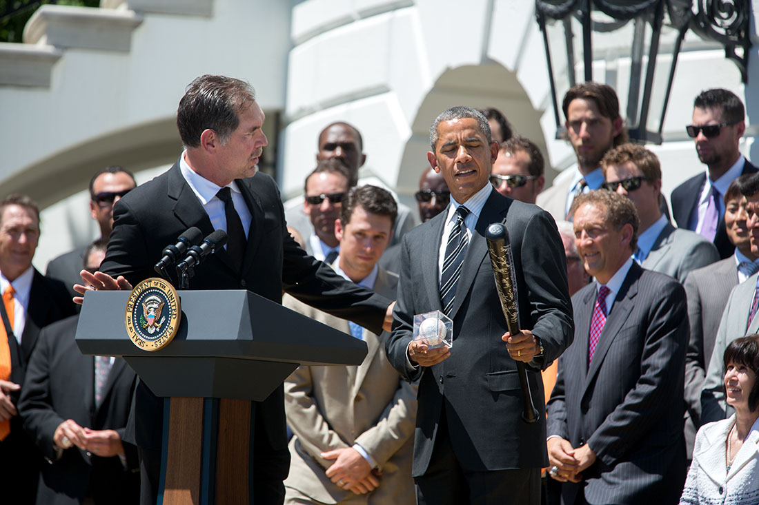 President Barack Obama examines the autographed baseball and bat