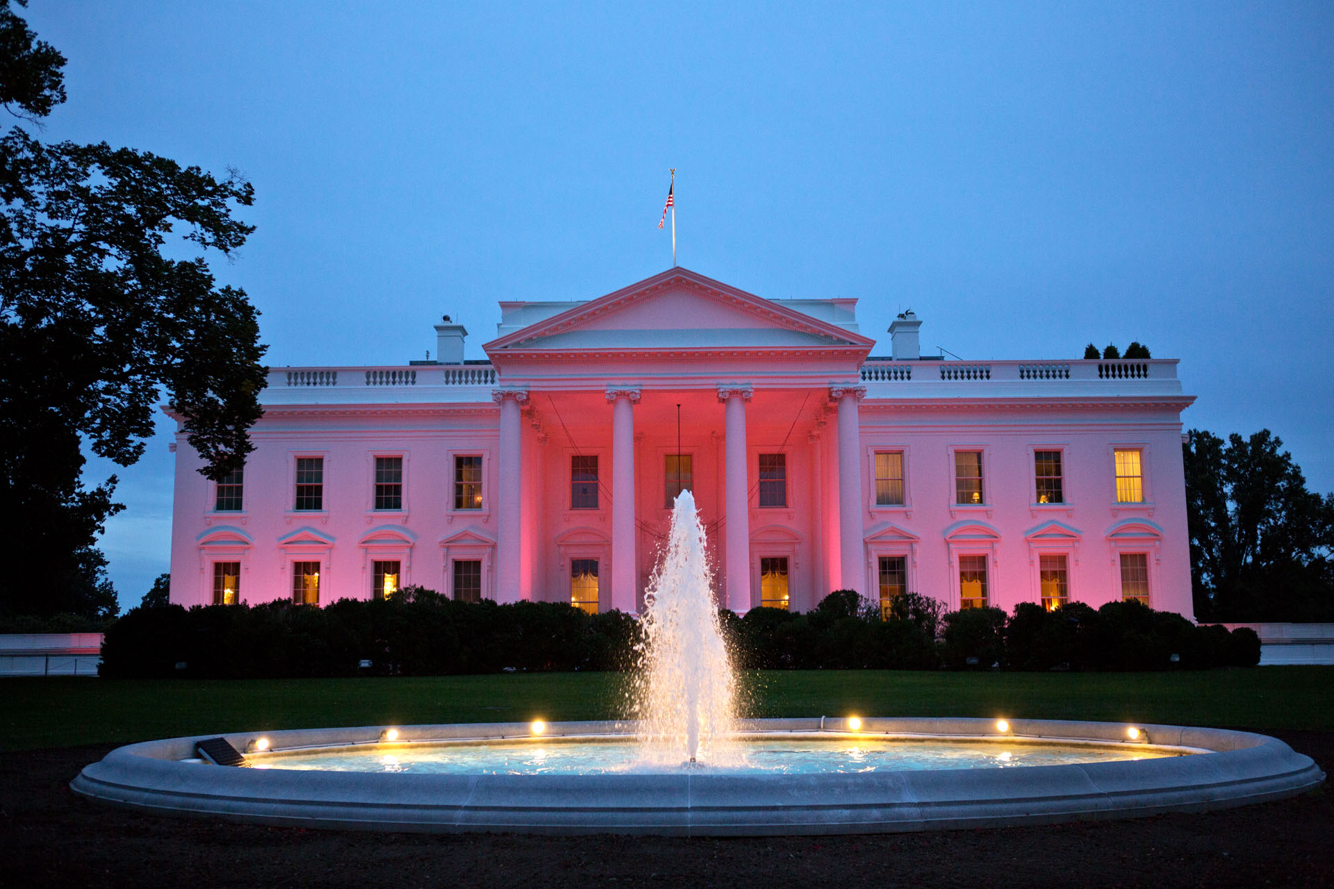 The North Portico exterior of the White House is illuminated pink
