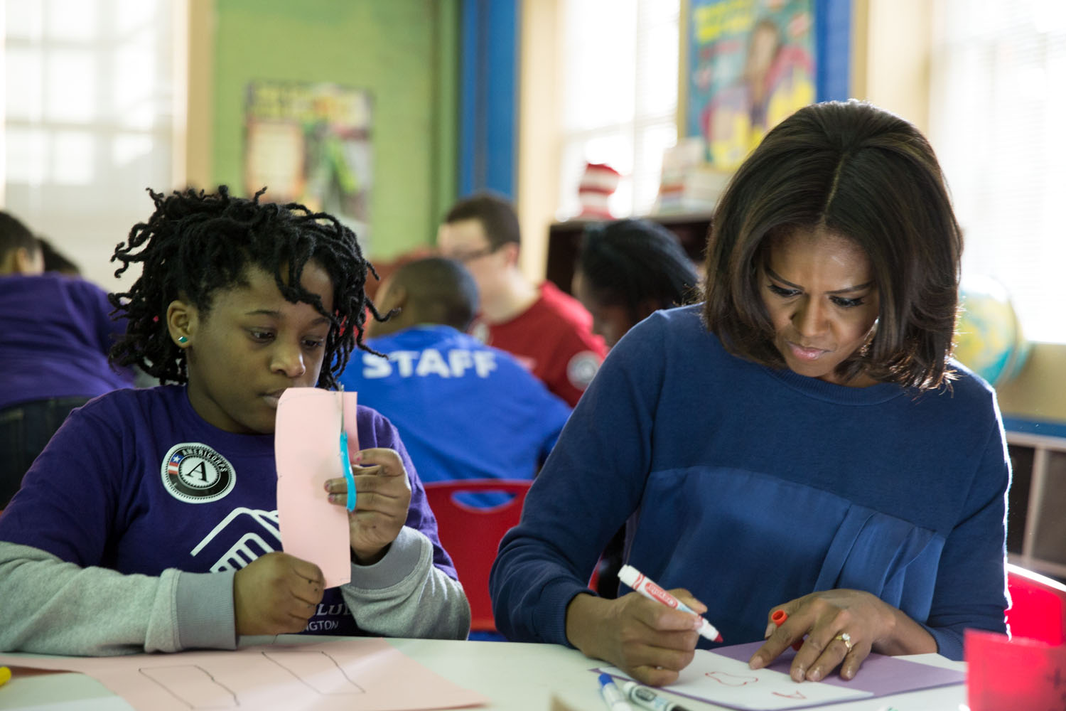 First Lady Michelle Obama works with a young girl during a community service project at the Boys & Girls Club of Greater Washington