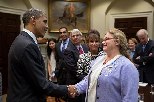 President Barack Obama talks with participants before a meeting with small business owners