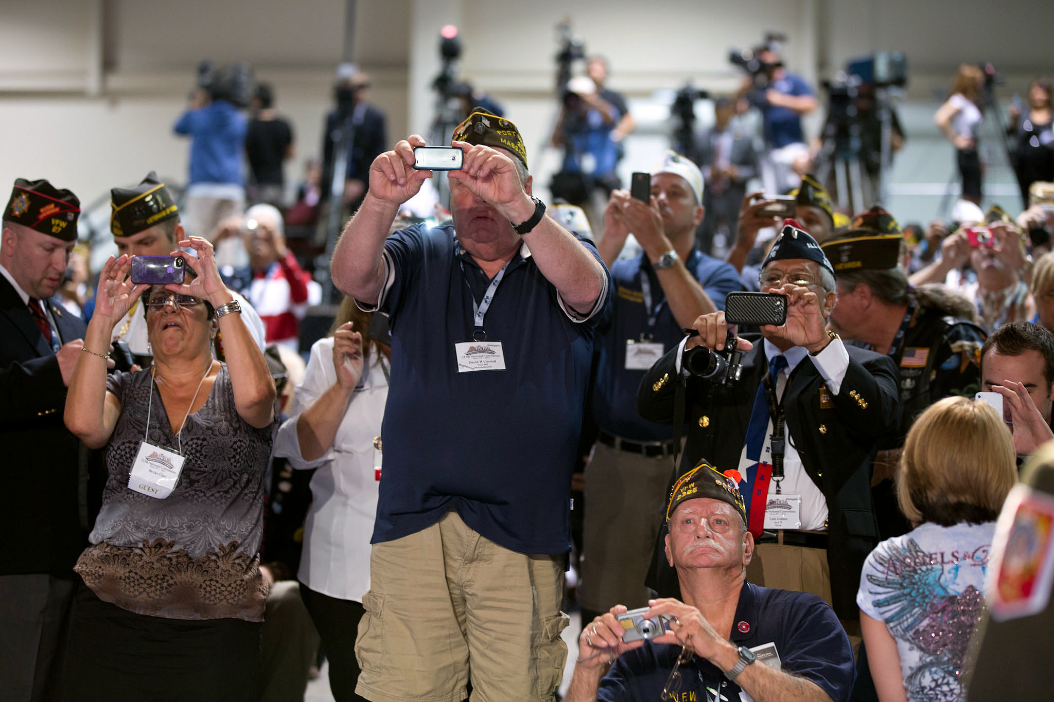 Attendees take photos as President Barack Obama delivers remarks at the 113th National Convention of the Veterans of Foreign Wars 