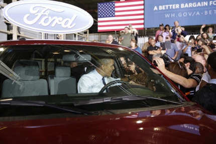 President Barack Obama greets Ford employees from the driver's seat of a Ford truck after delivering remarks on the economy at the Ford Kansas City Stamping Plant