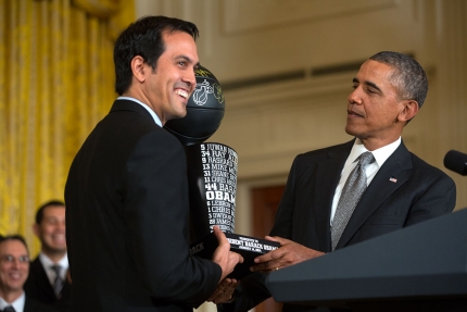 Miami Heat Coach Erik Spoelstra presents President Barack Obama with a team trophy