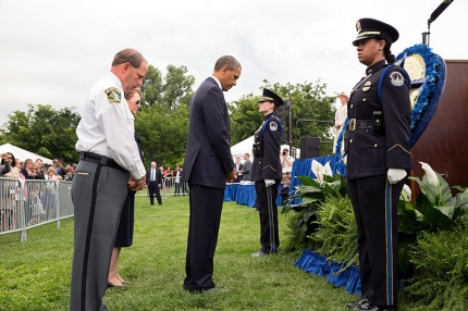 President Barack Obama bows his head after placing a flower in a wreath during the National Peace Officers Memorial Service