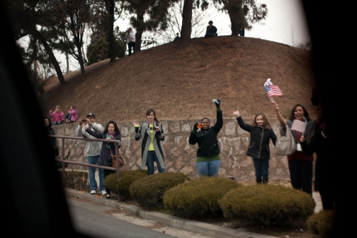 People Wave Along President Barack Obama's Motorcade Route