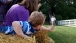 A Boy Leans Over a Bale of Hay to Wave to President Obama 