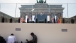 Photojournalists Evan Vucci and Jewel Samad work in the foreground as President Barack Obama delivers remarks at the Brandenburg Gate in Berlin
