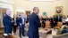 The President speaks with staff in the Oval Office