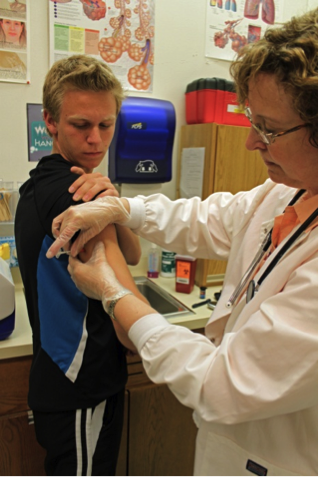 A school nurse administers a vaccination.