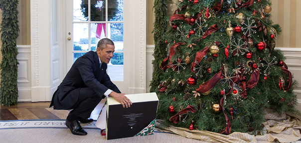 President Obama opens a gift in the Oval Office