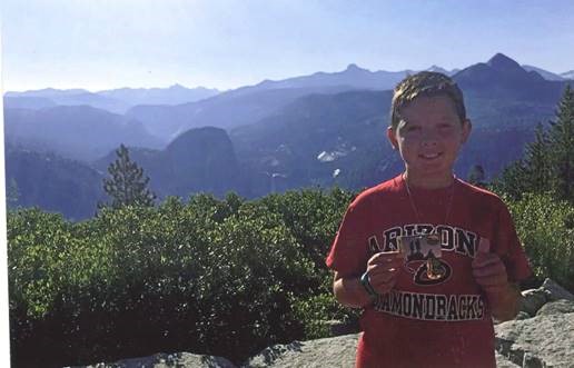 4th Grader Alexander showing off his Every Kid in a Park Pass at Yosemite National Park