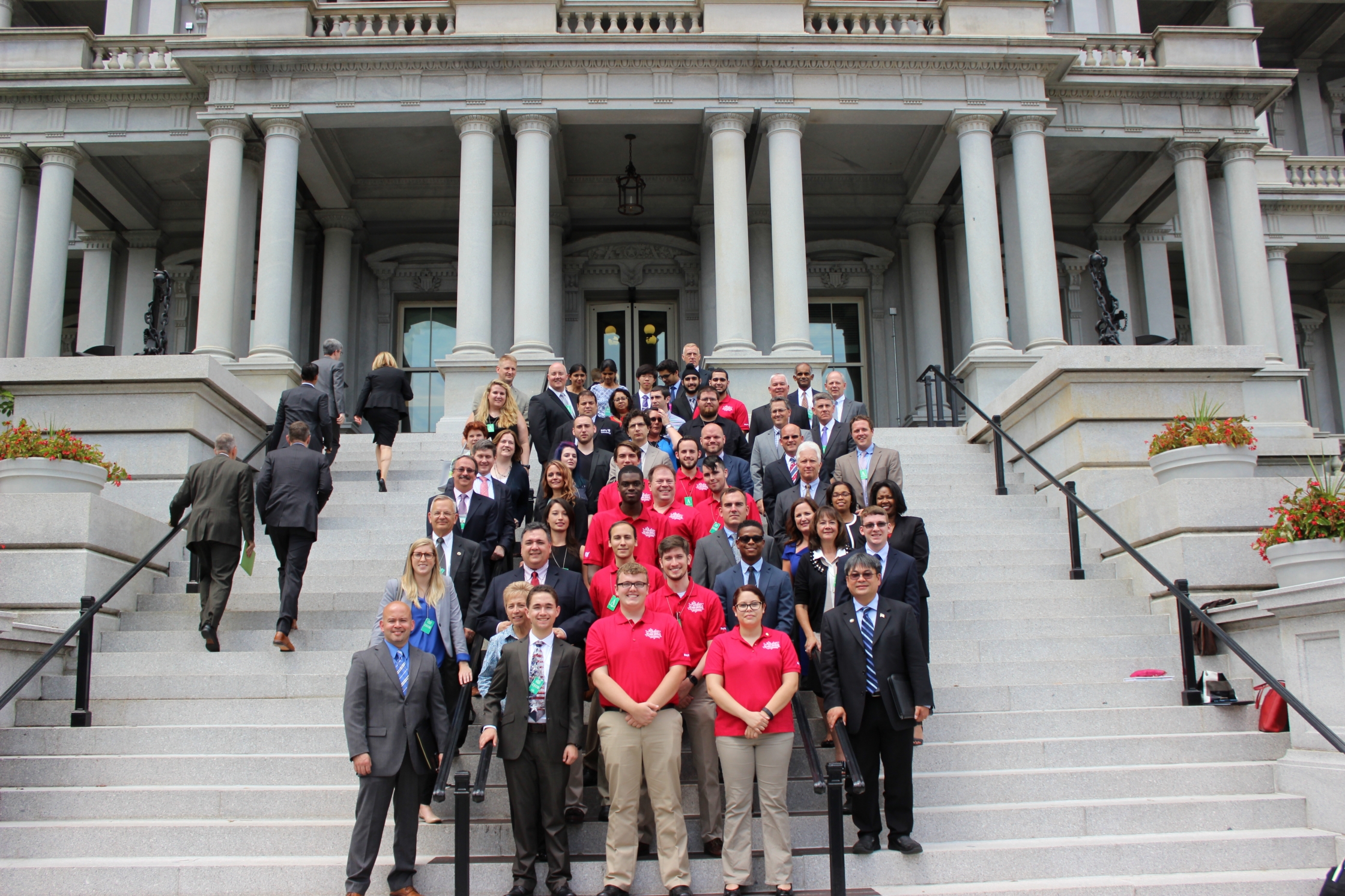 Attendees of the Cybersecurity Competition Workforce event pose outside the Eisenhower Executive Office Building.