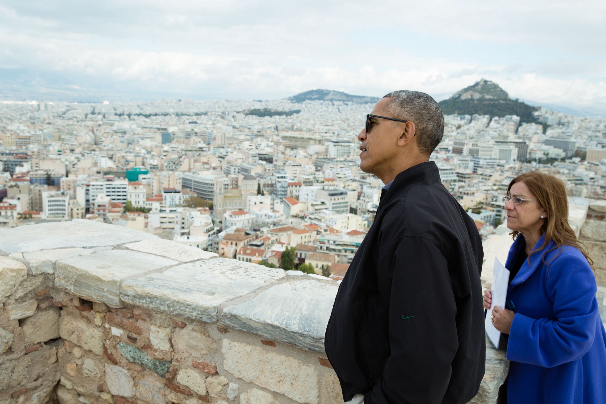  President Barack Obama looks at the view from Belvedere Tower during a tour of the Acropolis in Athens, Greece, Nov. 16, 2016. Dr. Eleni Banou, Director, Ephorate of Antiquities for Athens, Ministry of Culture, leads the tour. (Official White House Photo by Pete Souza)