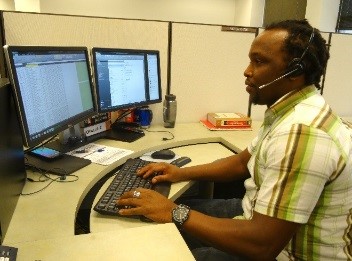 Victor, a Kenyan immigrant, shown working at his computer. 