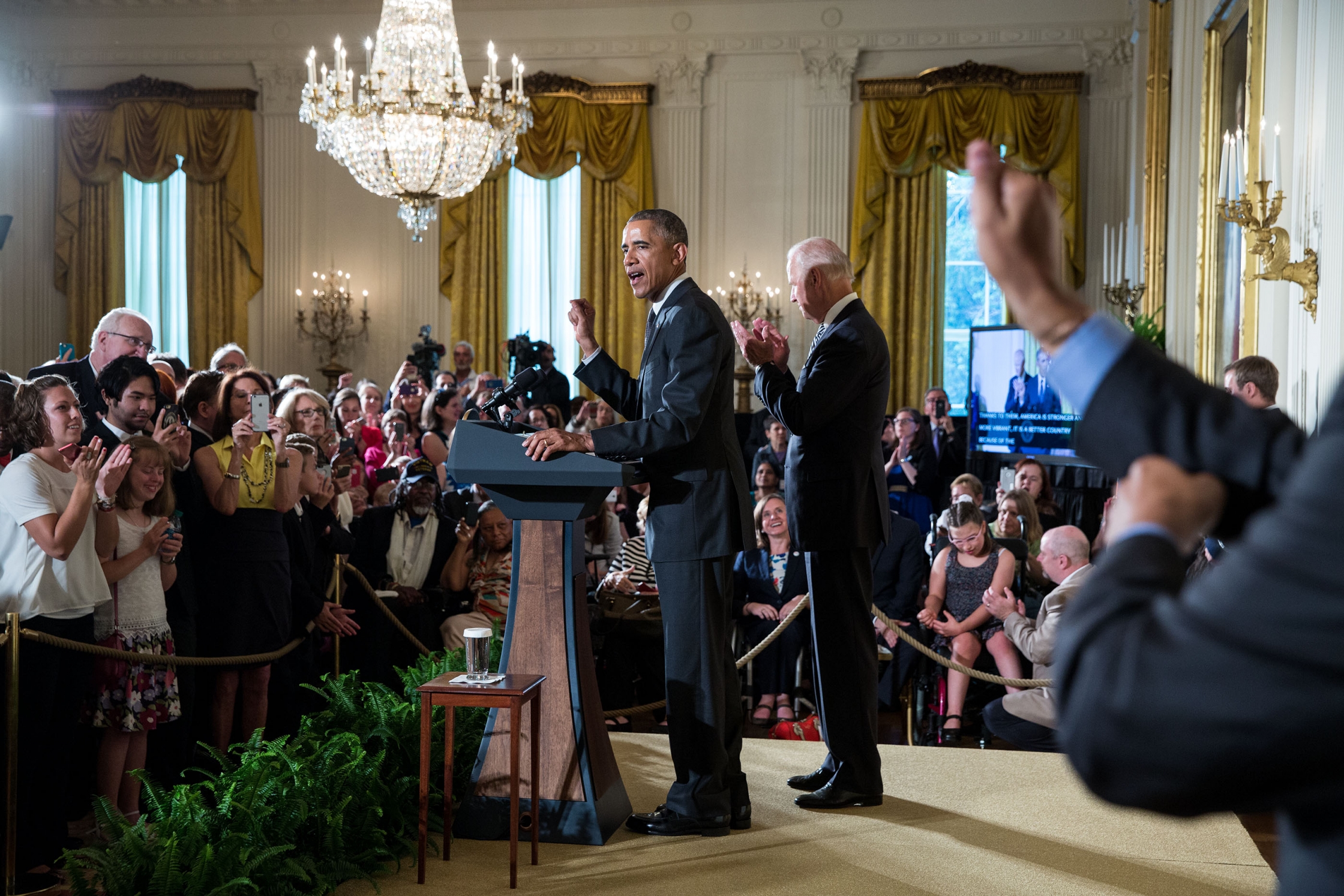 An interpreter signs in the foreground while President Barack Obama, with Vice President Joe Biden, delivers remarks during a reception for the 25th anniversary of the Americans with Disabilities Act (ADA) in the East Room of the White House, July 20, 2015. (Official White House Photo by Pete Souza)